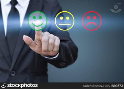 Businessman pressing smiley face icon on virtual screen. Concept of satisfaction evaluation and feedback.