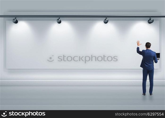 Businessman pressing virtual button on the wall lit with spotlights. Businessman pressing virtual button on the wall lit with spotlig