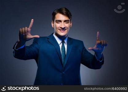 Businessman pressing virtual buttons on gray background