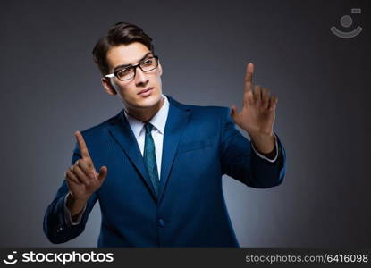 Businessman pressing virtual buttons on gray background