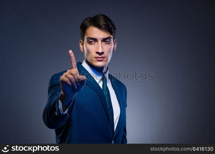 Businessman pressing virtual buttons on gray background