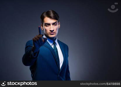 Businessman pressing virtual buttons on gray background