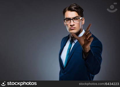 Businessman pressing virtual buttons on gray background