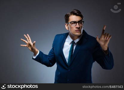 Businessman pressing virtual buttons on gray background