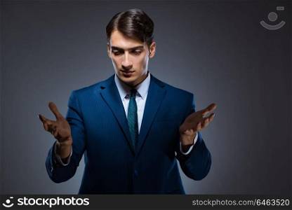 Businessman pressing virtual buttons on gray background