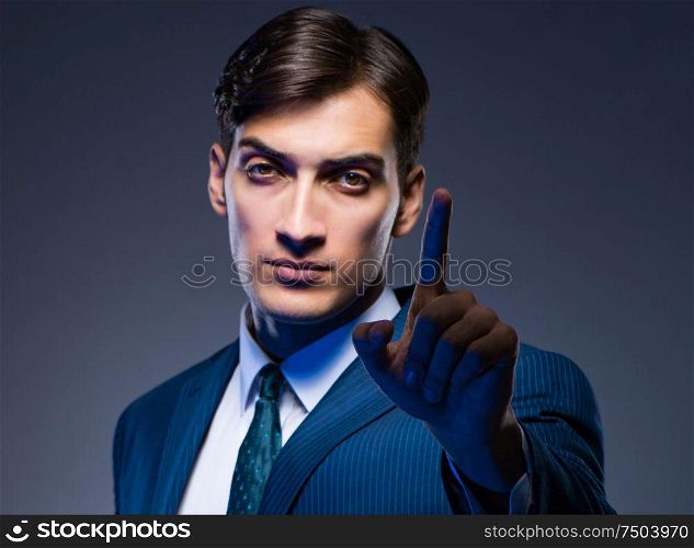 Businessman pressing virtual buttons on gray background. The businessman pressing virtual buttons on gray background