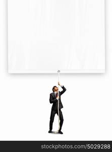 Businessman pulling banner. Image of businessman pulling blank banner. Place for text