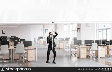Businessman pulling banner. Young businessman in office and blank banner. Place for text