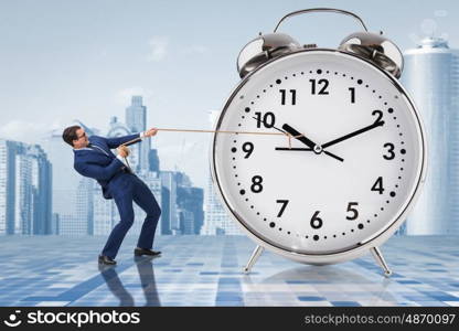 Businessman pulling clock in time management concept