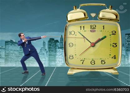 Businessman pulling clock in time management concept