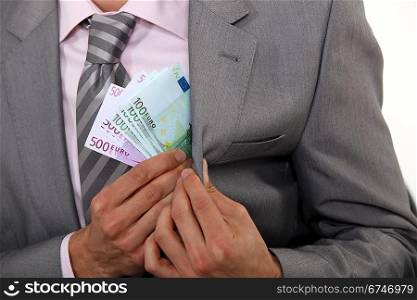 Businessman pulling money out of pocket