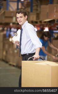 Businessman Pulling Pallet In Warehouse