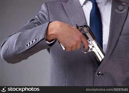 Businessman pulling the gun out of pocket