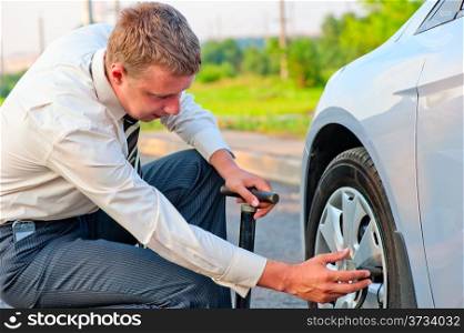 businessman pumps car tire pump