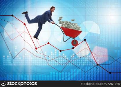 Businessman pushing money wheelbarrow down the chart