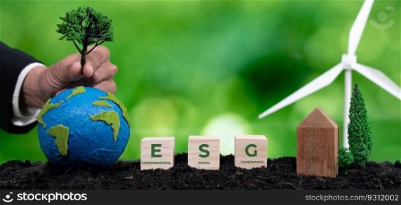 Businessman put tree on paper earth with ESG symbol cube as concept for forest regeneration by ethical corporate company with environmental protection awareness for green environment in future. Alter. Businessman put tree on paper earth with ESG for forest regeneration. Alter