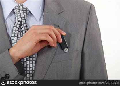 businessman putting a flash drive in his pocket