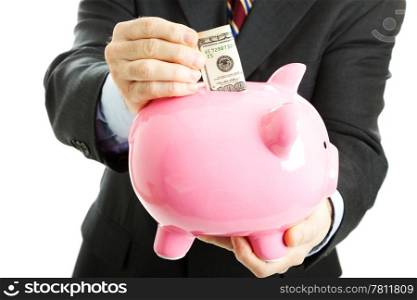 Businessman putting a hundred dollar bill in his piggy bank. White background.