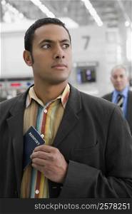Businessman putting a passport in his pocket