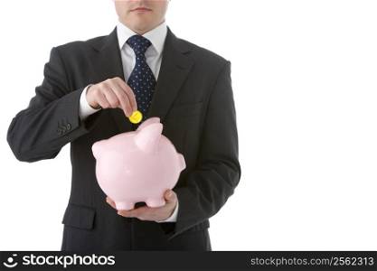 Businessman Putting Coin Into Piggy Bank