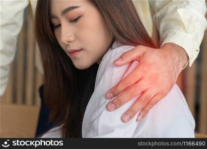 Businessman putting hand on the shoulder of female employee in office at work. She unhappy and feeling displeased with inappropriate actions his boss. Concept of sexual harassment in workplace