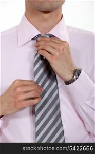 businessman putting his tie on