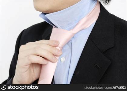 businessman putting on a necktie