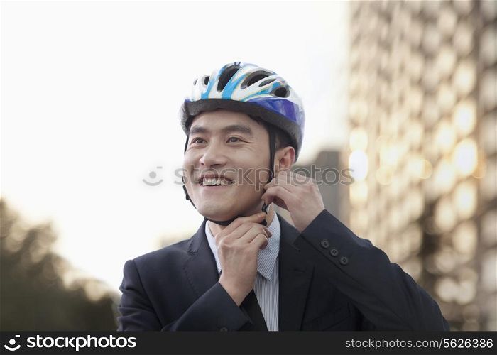 Businessman putting on cycling helmet