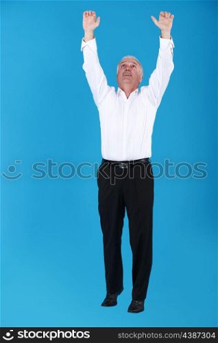Businessman reaching into the air