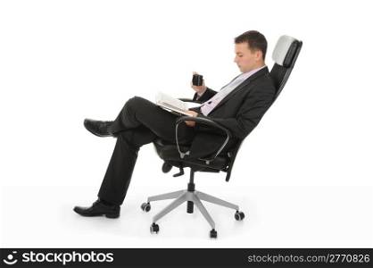 Businessman reading a book and drinking coffee sitting in a chair in a bright office. Isolated on white background