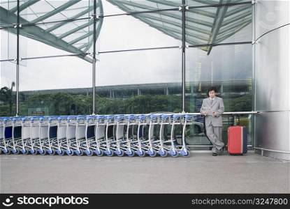 Businessman reading a document and waiting outside an airport