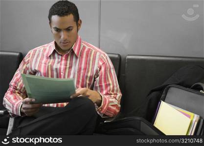 Businessman reading a file in the waiting room of an airport