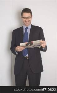Businessman reading a newspaper and smiling
