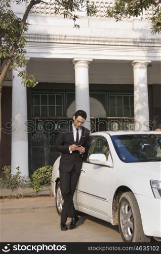 Businessman reading an sms on a mobile phone , INDIA , DELHI