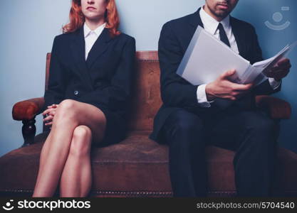 Businessman reading document with woman sitting next to him