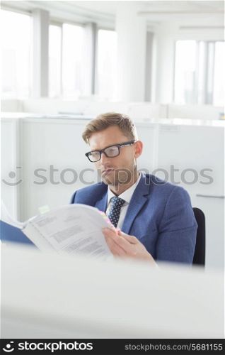 Businessman reading file in creative office