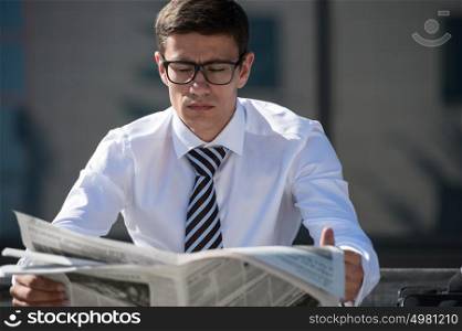 Businessman reading newspaper outdoor