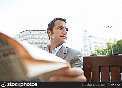 Businessman Reading Newspaper Outdoors