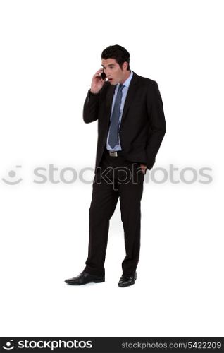 Businessman receiving shocking news over the telephone