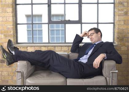 Businessman reclining on a couch