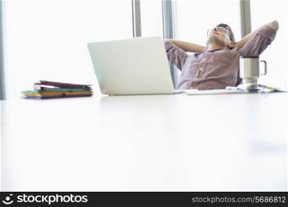 Businessman relaxing at desk in creative office