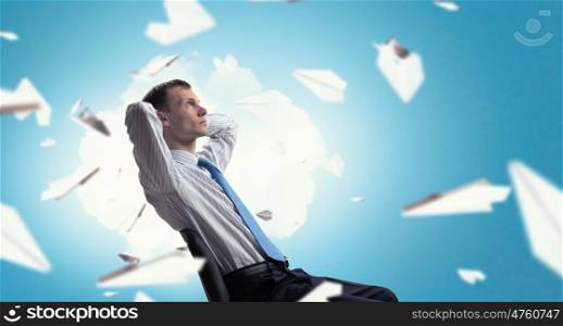 Businessman relaxing in chair. Relaxed businessman at the office sitting with his hands behind his head