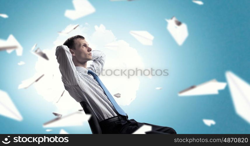 Businessman relaxing in chair. Relaxed businessman at the office sitting with his hands behind his head