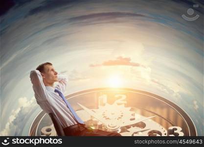 Businessman relaxing in his chair. Relaxed businessman sitting back with his hands behind his head