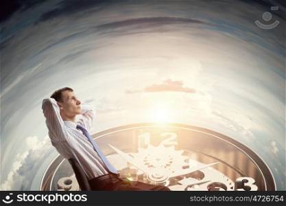 Businessman relaxing in his chair. Relaxed businessman sitting back with his hands behind his head