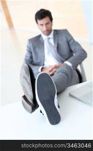 Businessman relaxing wih feet on desk