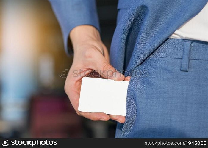 businessman removing blank white card from his pocket. High resolution photo. businessman removing blank white card from his pocket. High quality photo