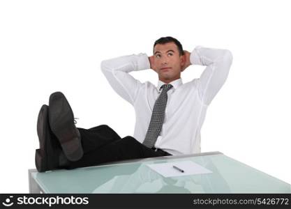 Businessman resting feet on desk
