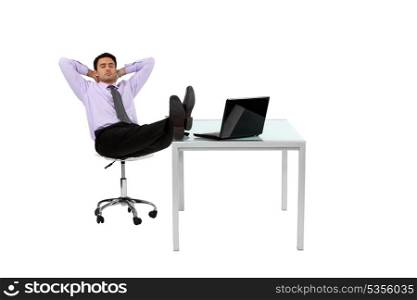 Businessman resting his feet on desk