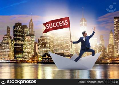 Businessman riding paper boat ship in success concept